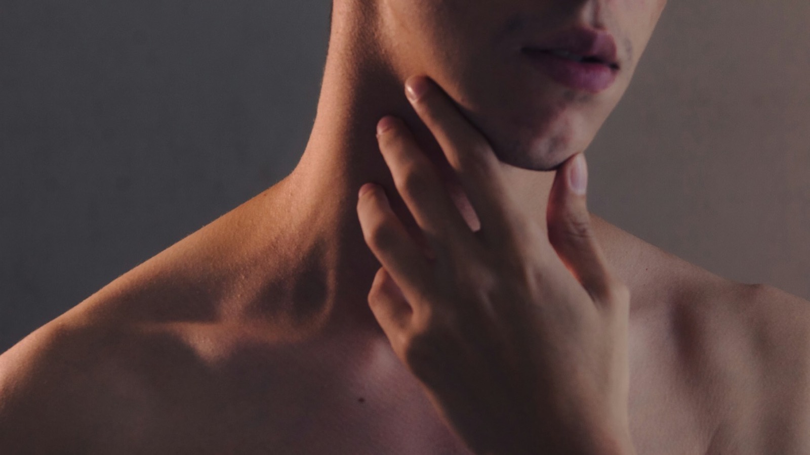Close view of a person&rsquo;s neck and collarbone in warm side light